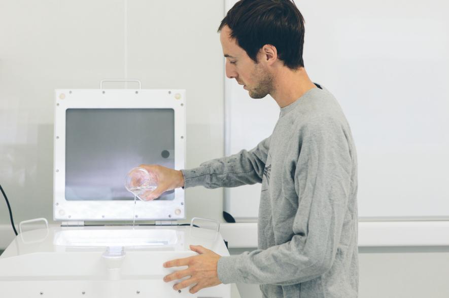 LifeWatch-VLIZ-onderzoeker Jonas giet een planktonstaal op de zooscan